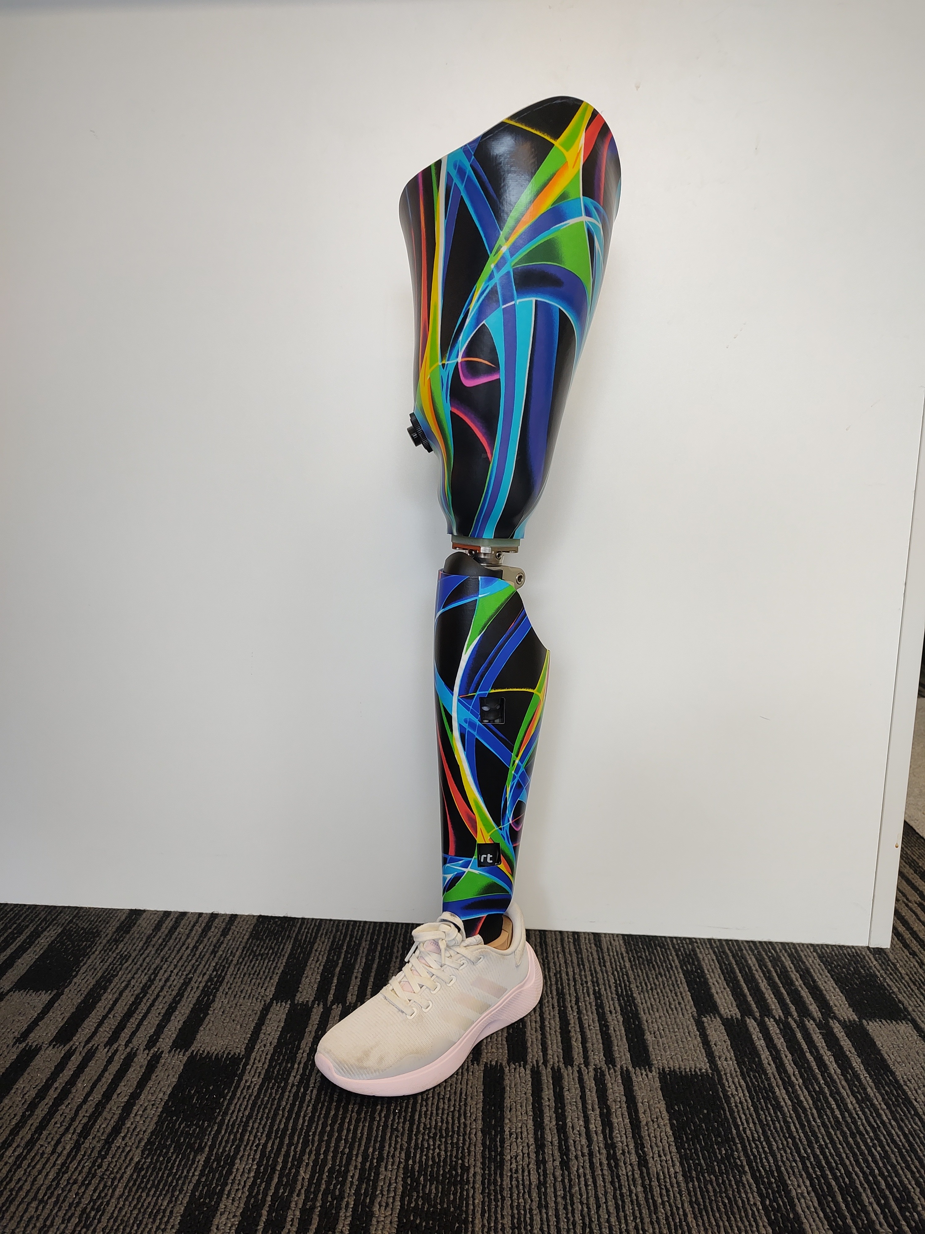 Prosthetic leg shown with white trainer shoe in colpurful graphic style